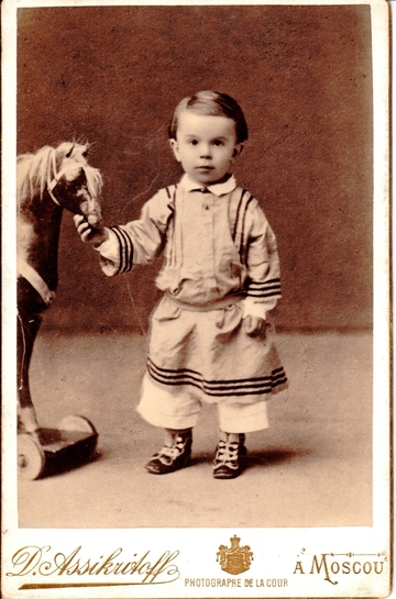 Василенко С. Н. Фото в детском возрасте. Стоит  фас  правой рукой держит морду лошадки