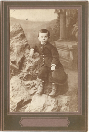 Василенко С. Н. Фото в детском возрасте. Фас  сидит  шляпа в левой руке
